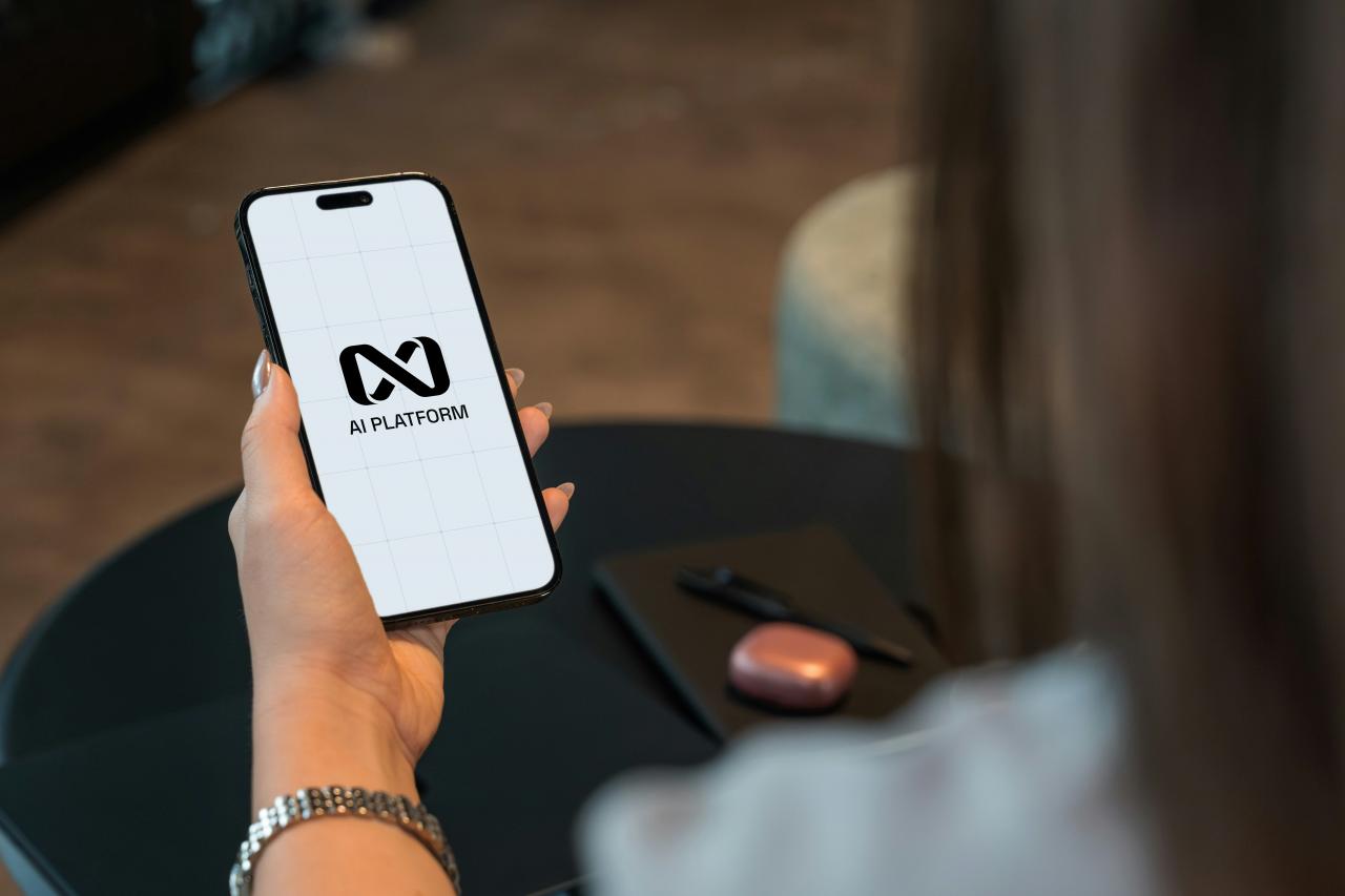 Orang yang memegang smartphone dengan logo di layar.