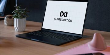Laptop menampilkan logo integrasi ai di meja